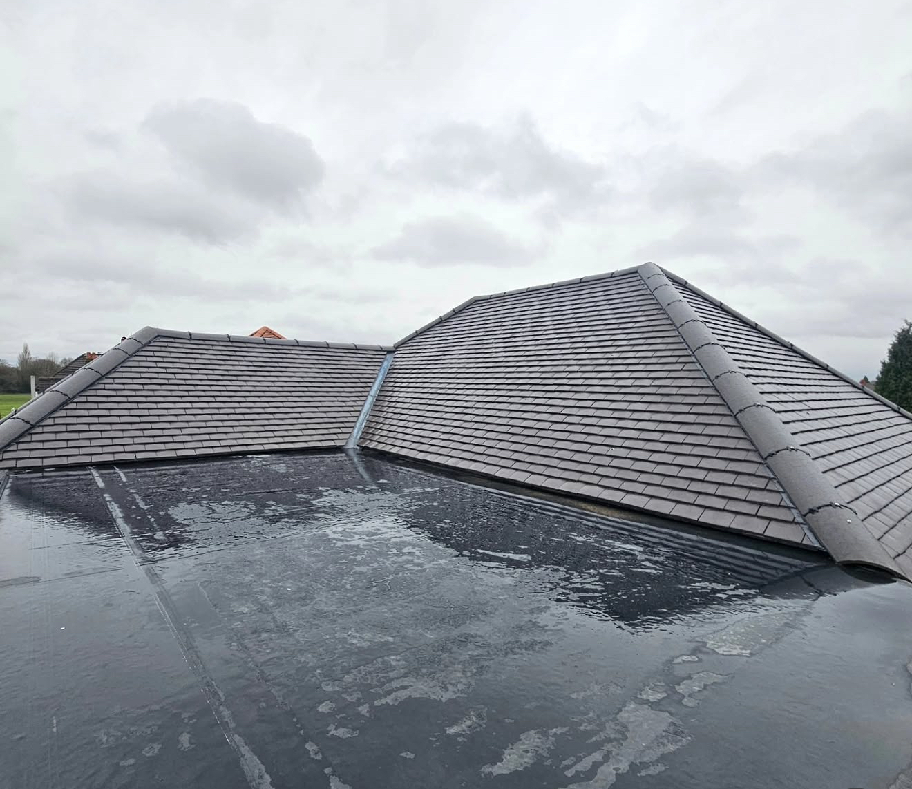 Single-ply flat roof between two newly tiled pitched roof slopes