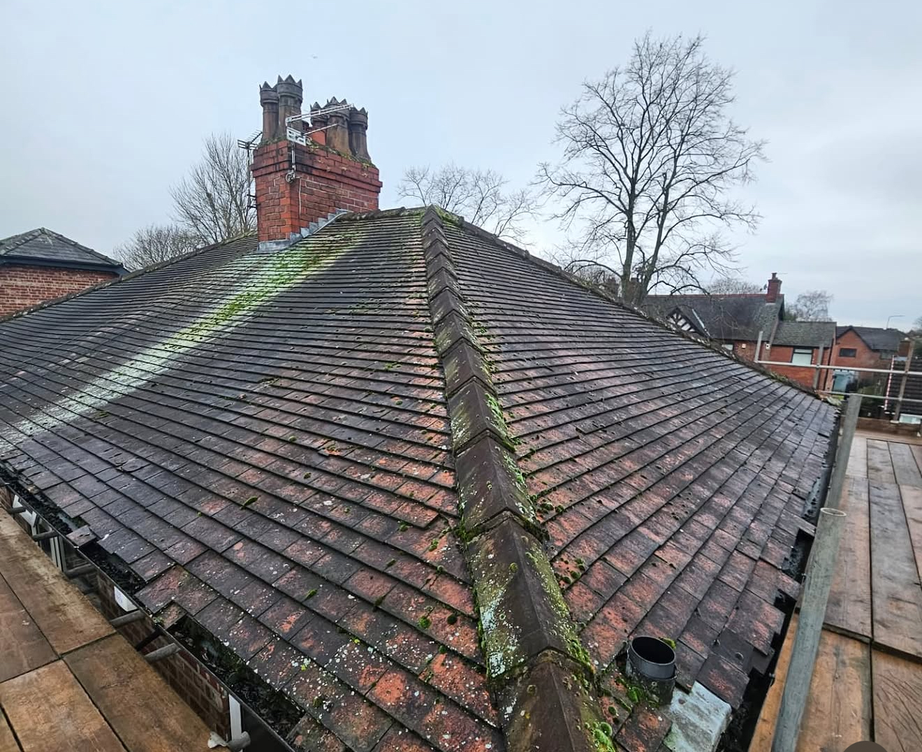 Original mossy clay tiled roof with worn ridge before replacement