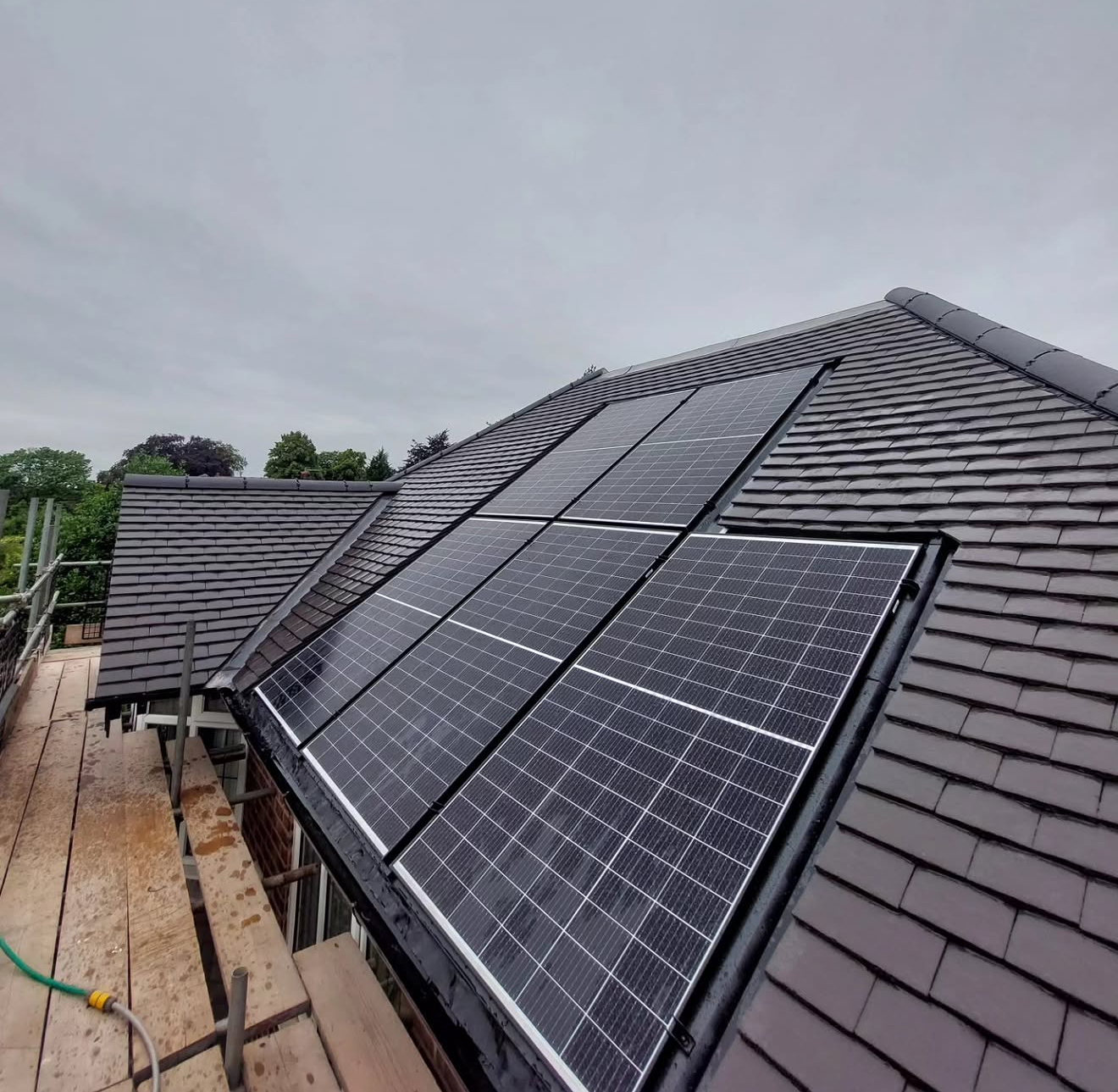 Close view of solar panels set into a new grey tiled roof slope