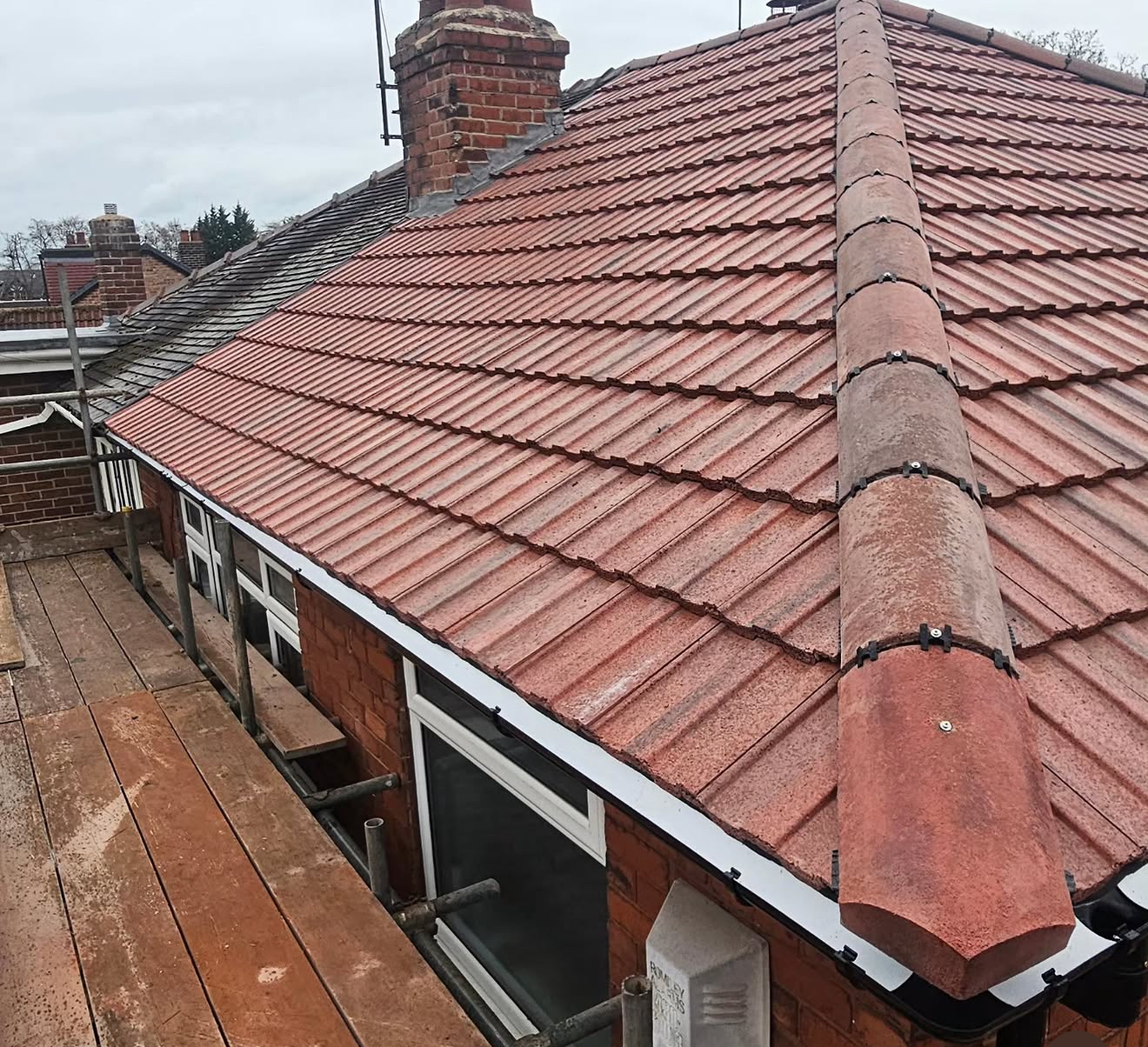Red concrete tiled roof with a long dry-fix ridge run and new white fascia